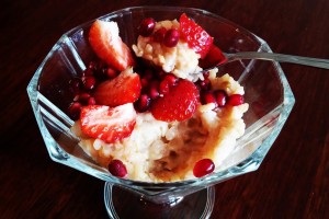 Waniliowy pudding z brązowego ryżu z granatem i truskawkami.