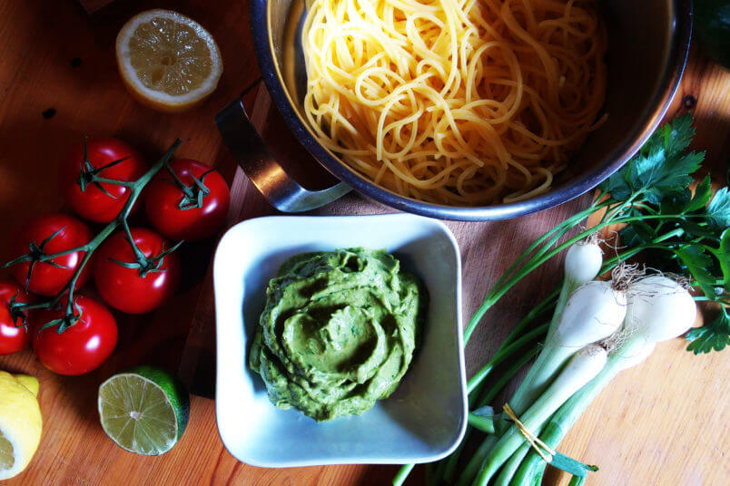 Pasta with creamy avocado sauce, herbs and vegan parmesan cheese