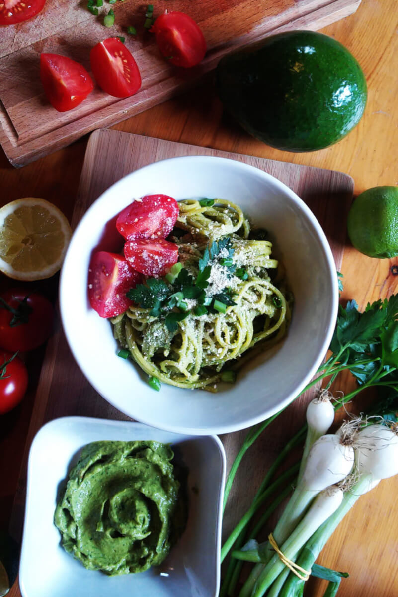 Pasta with creamy avocado sauce, herbs and vegan parmesan cheese