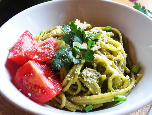 Pasta with creamy avocado sauce, herbs and vegan parmesan cheese