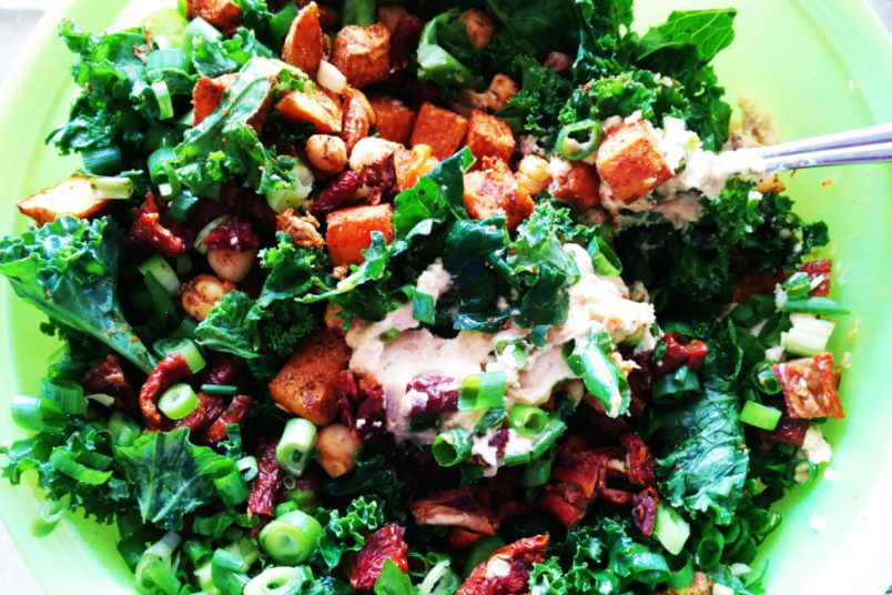 Salad with roasted sweet potatoes, chickpeas, dried tomatoes, hummus and kale