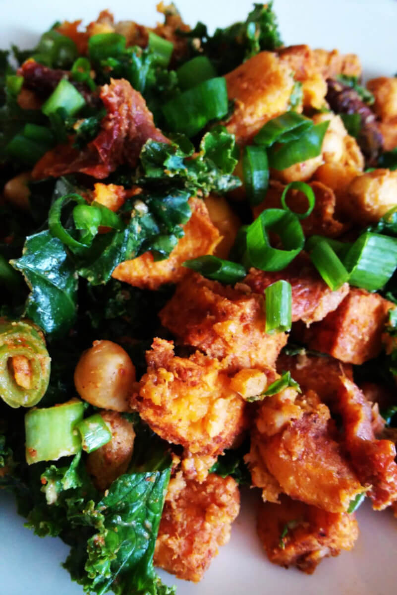 Salad with roasted sweet potatoes, chickpeas, dried tomatoes, hummus and kale